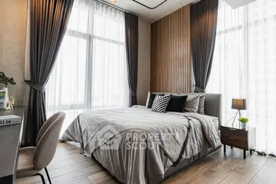 Luxurious bedroom with modern decor and large windows offering abundant natural light.
