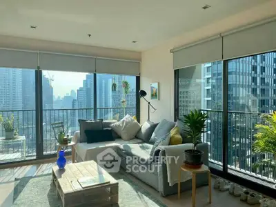 Spacious living room with large windows offering stunning city views and abundant natural light.