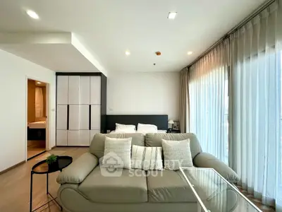 Modern living room with stylish sofa and large windows in a bright apartment.