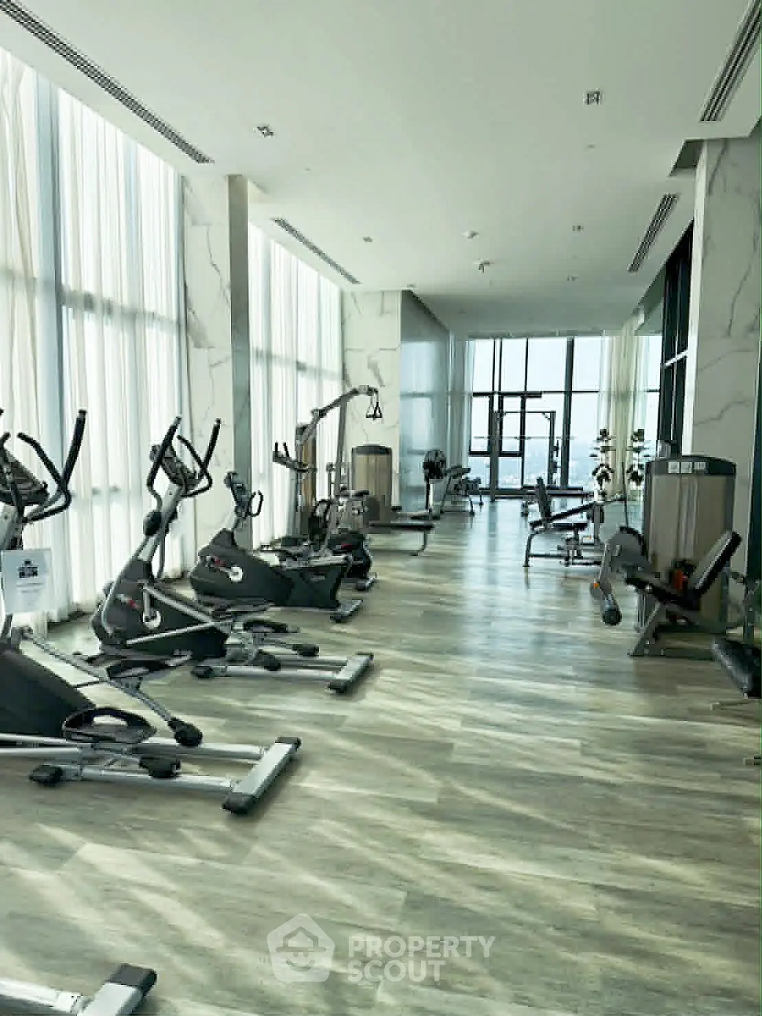 Luxurious high-rise gym with modern equipment and panoramic city views.