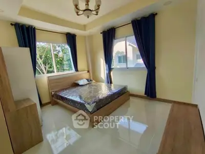 Spacious bedroom with large windows and elegant decor in a modern home.