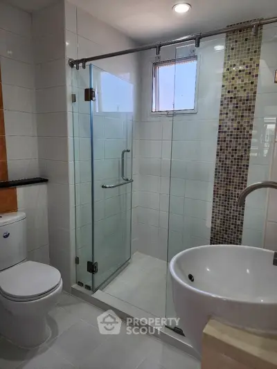 Modern bathroom with glass shower enclosure and stylish fixtures