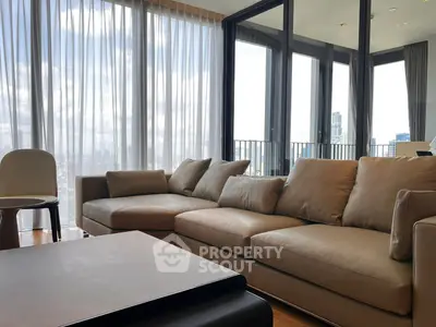 Luxurious living room with modern furniture and stunning city view through large windows.