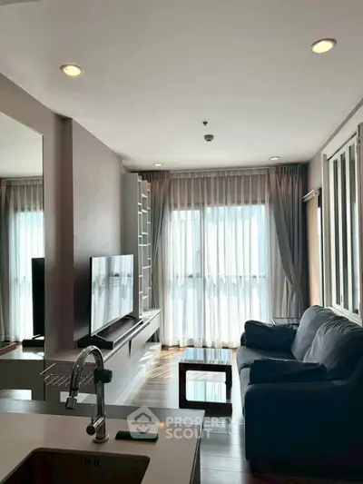 Modern living room with sleek furniture and large windows for natural light.