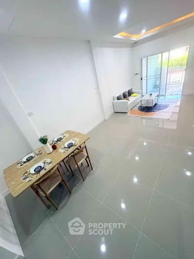 Spacious modern living room with elegant dining area and patio access.