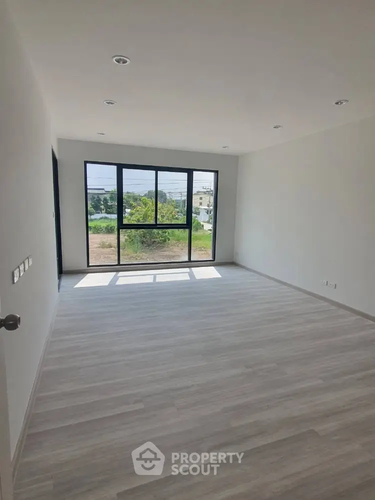 Spacious empty room with large window and natural light