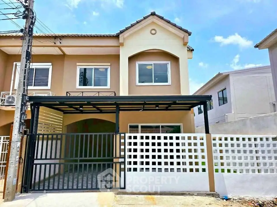 Charming two-story townhouse with gated entrance and modern facade in a serene neighborhood.