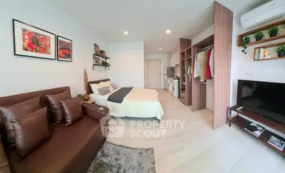 Modern studio apartment with cozy living area and open wardrobe