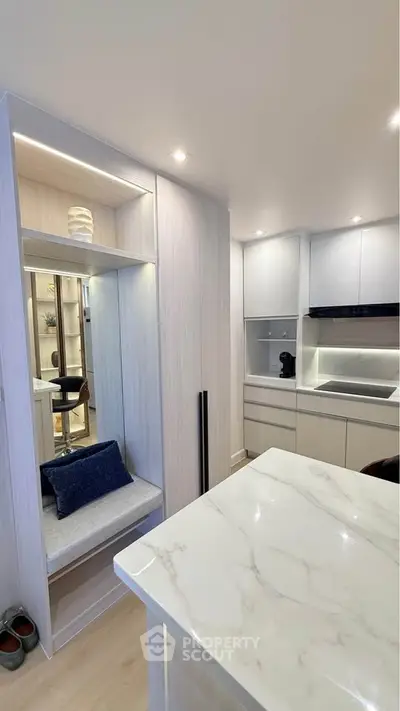 Modern kitchen with sleek cabinetry and marble countertop in stylish apartment
