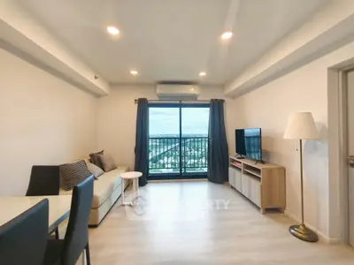 Modern living room with balcony view, sleek furniture, and natural light.