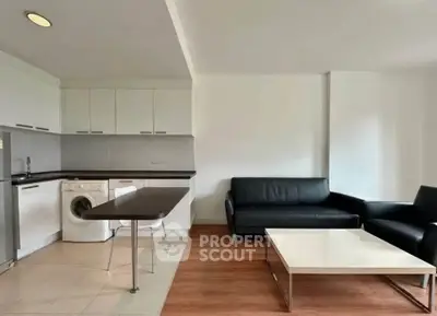 Modern open-plan living room with sleek kitchen and stylish furniture, perfect for urban living.