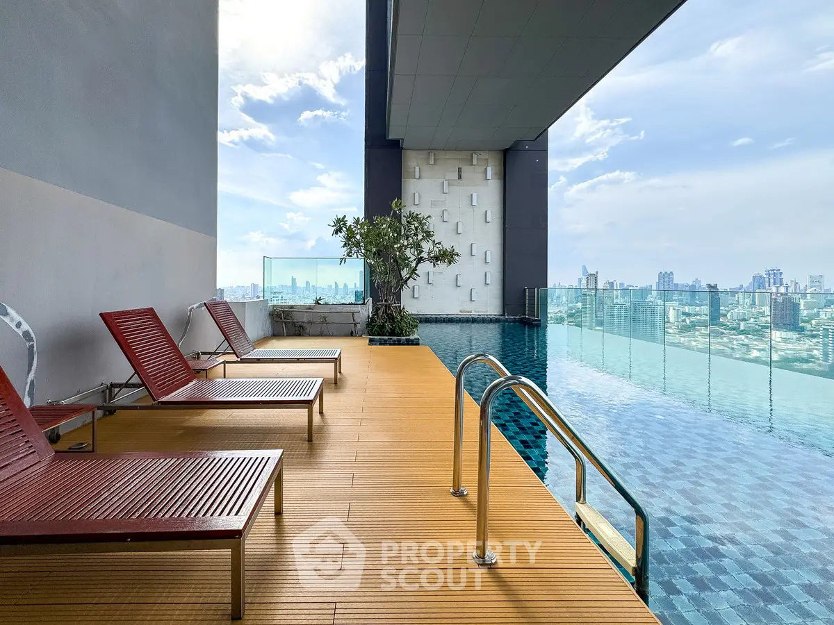 Luxurious rooftop infinity pool with stunning city skyline view and modern lounge chairs.