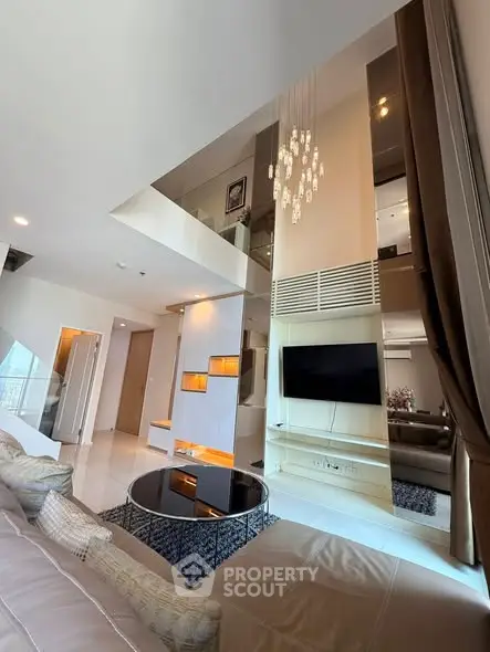 Luxurious modern living room with high ceiling and elegant chandelier in a stylish apartment.