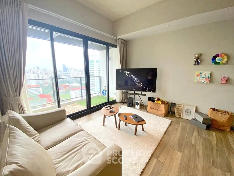 Modern living room with large windows and city view, featuring cozy seating and stylish decor.