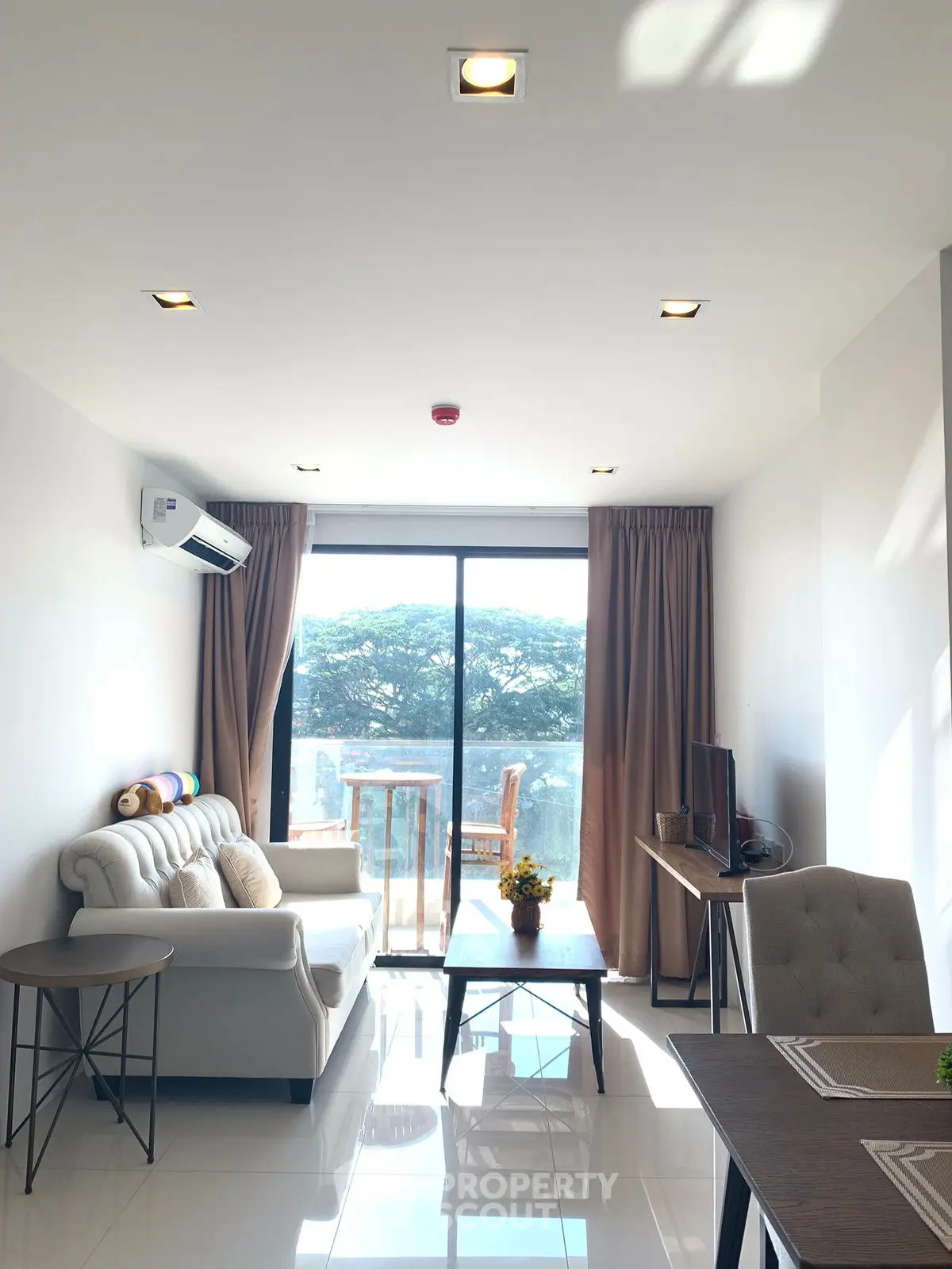 Bright modern living room with large window and stylish furniture, offering a serene view.