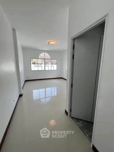 Spacious and bright room with glossy floors and large window, perfect for customization.
