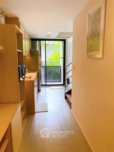 Modern kitchen with open layout and staircase leading to balcony view