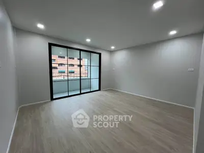 Spacious modern living room with large windows and wooden flooring