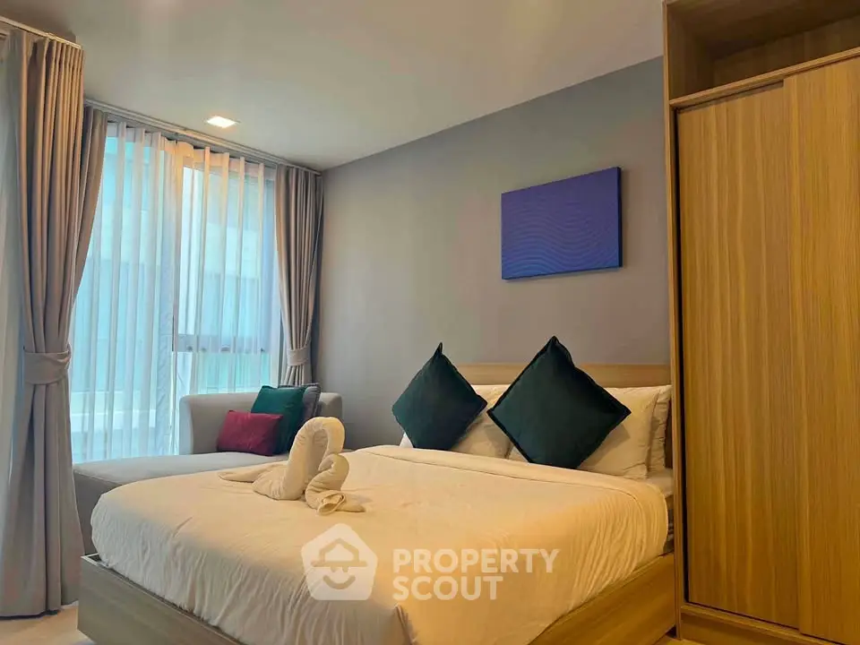 Modern bedroom with cozy bed, stylish decor, and ample natural light in a contemporary apartment.