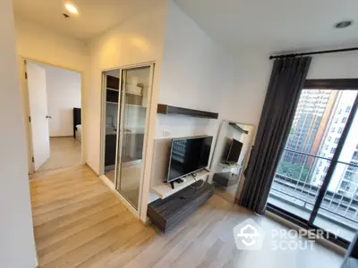 Modern living room with TV and balcony view in high-rise apartment