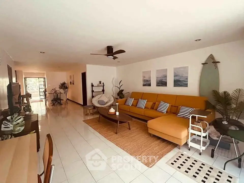 Spacious living room with modern decor and surfboard accent