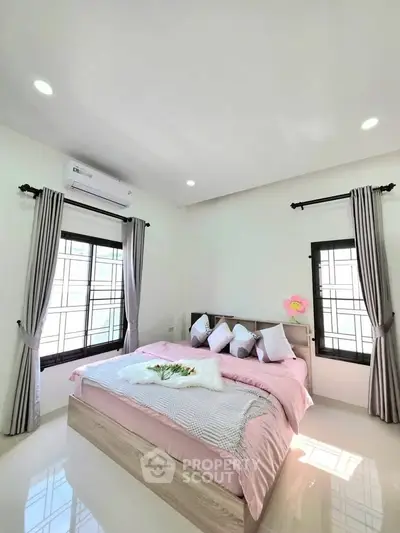 Bright and airy bedroom with modern decor and large windows for natural light.