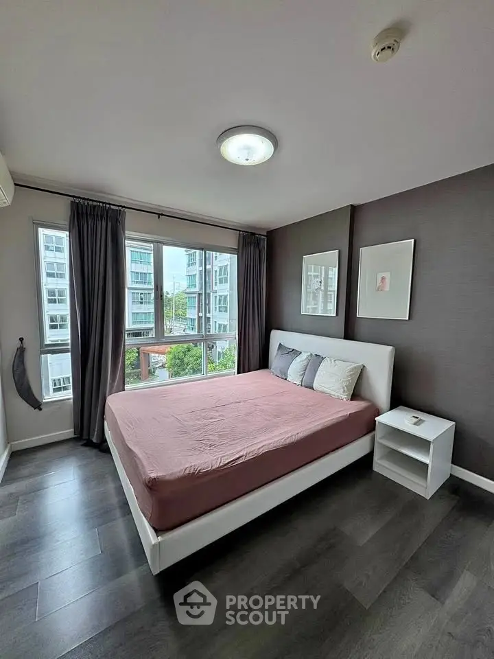 Modern bedroom with large windows and stylish decor in a high-rise apartment.