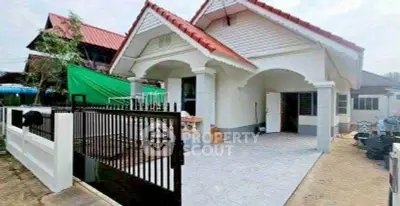 Charming single-story house with red roof and spacious front yard, perfect for family living.