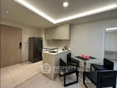 Modern kitchen with sleek design, featuring a compact dining area and contemporary appliances.