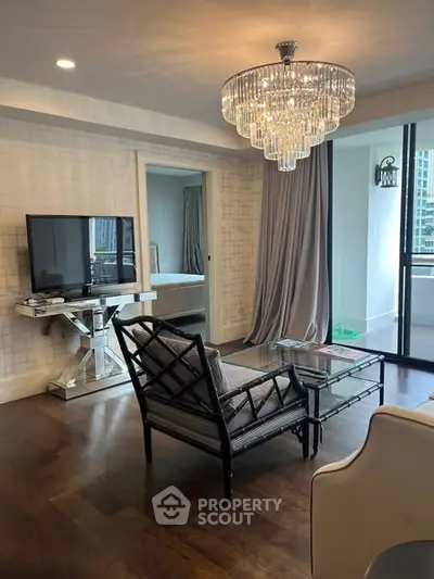 Elegant living room with chandelier and balcony access in modern apartment