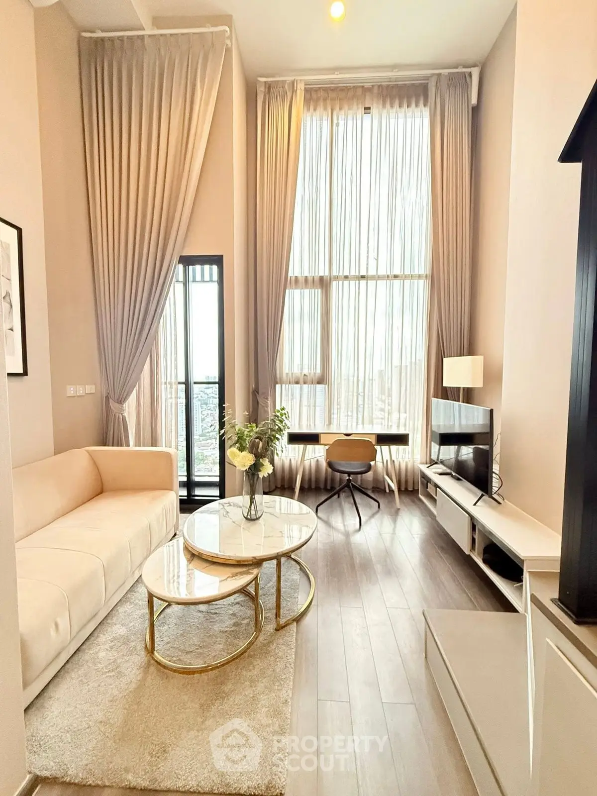 Luxurious high-ceiling living room with elegant decor and natural light