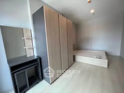 Modern minimalist bedroom with sleek wardrobe and bed frame, ideal for urban living.