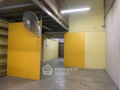 Spacious industrial storage area with high ceilings and shelving units.