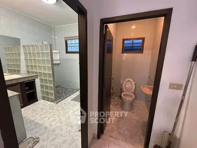 Spacious bathroom with separate toilet and modern tile design.
