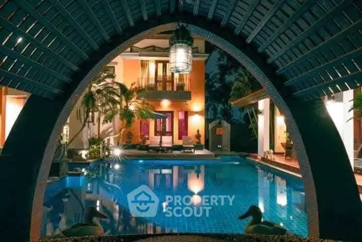 Luxurious villa with stunning pool view and elegant architecture at night.