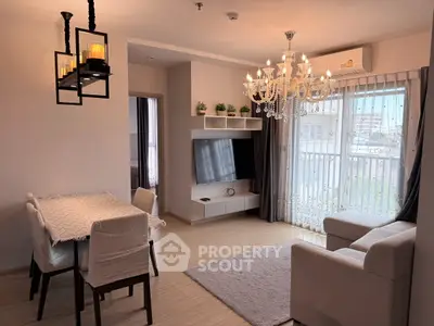 Elegant living room with chandelier, modern furniture, and large window offering city views.