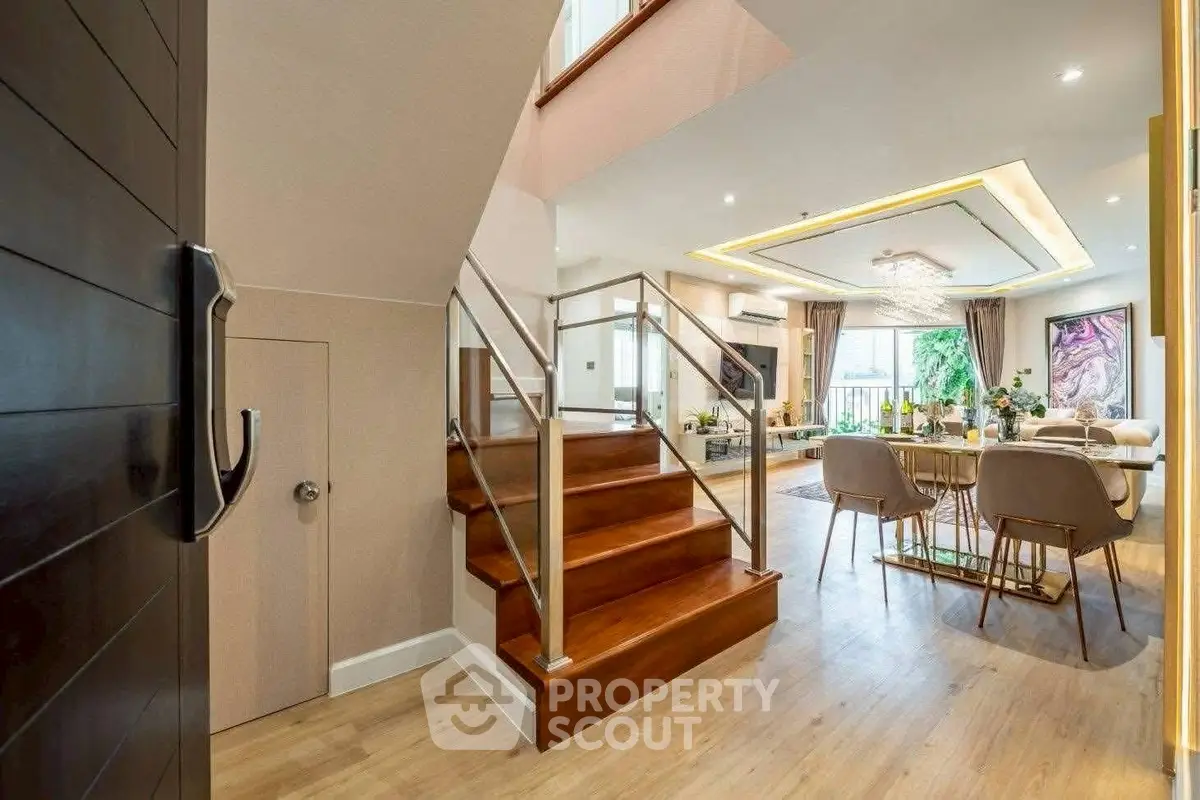 Luxurious open-plan living room with elegant dining area and modern staircase