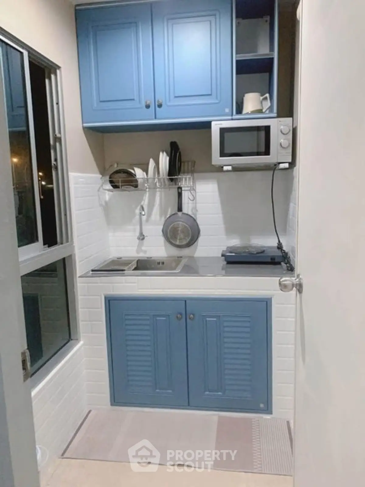 Charming compact kitchen with blue cabinets and modern appliances