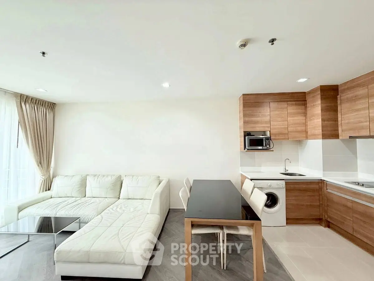 Modern open-layout living room with sleek kitchen and cozy white sofa