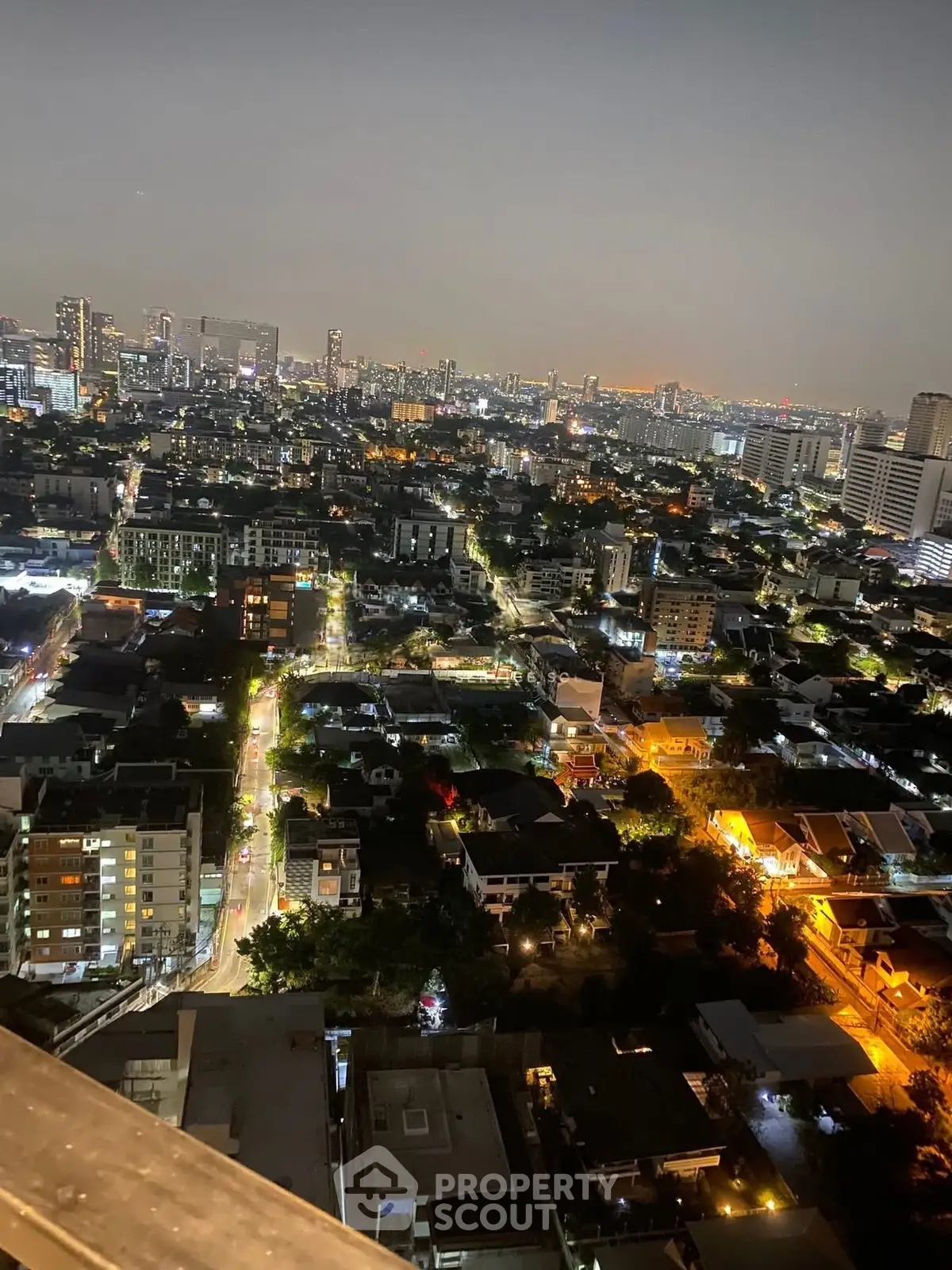 Stunning cityscape view from a high-rise building at night, showcasing vibrant city lights and skyline.
