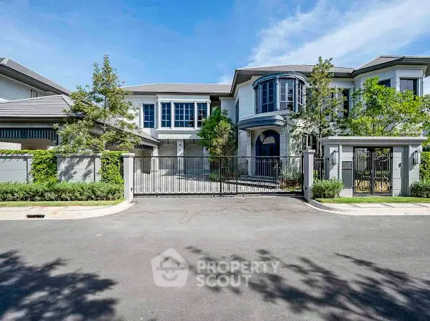 Luxurious modern mansion with elegant facade and gated entrance in a prestigious neighborhood.