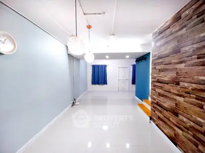 Spacious modern living room with stylish wood accent wall and elegant lighting.