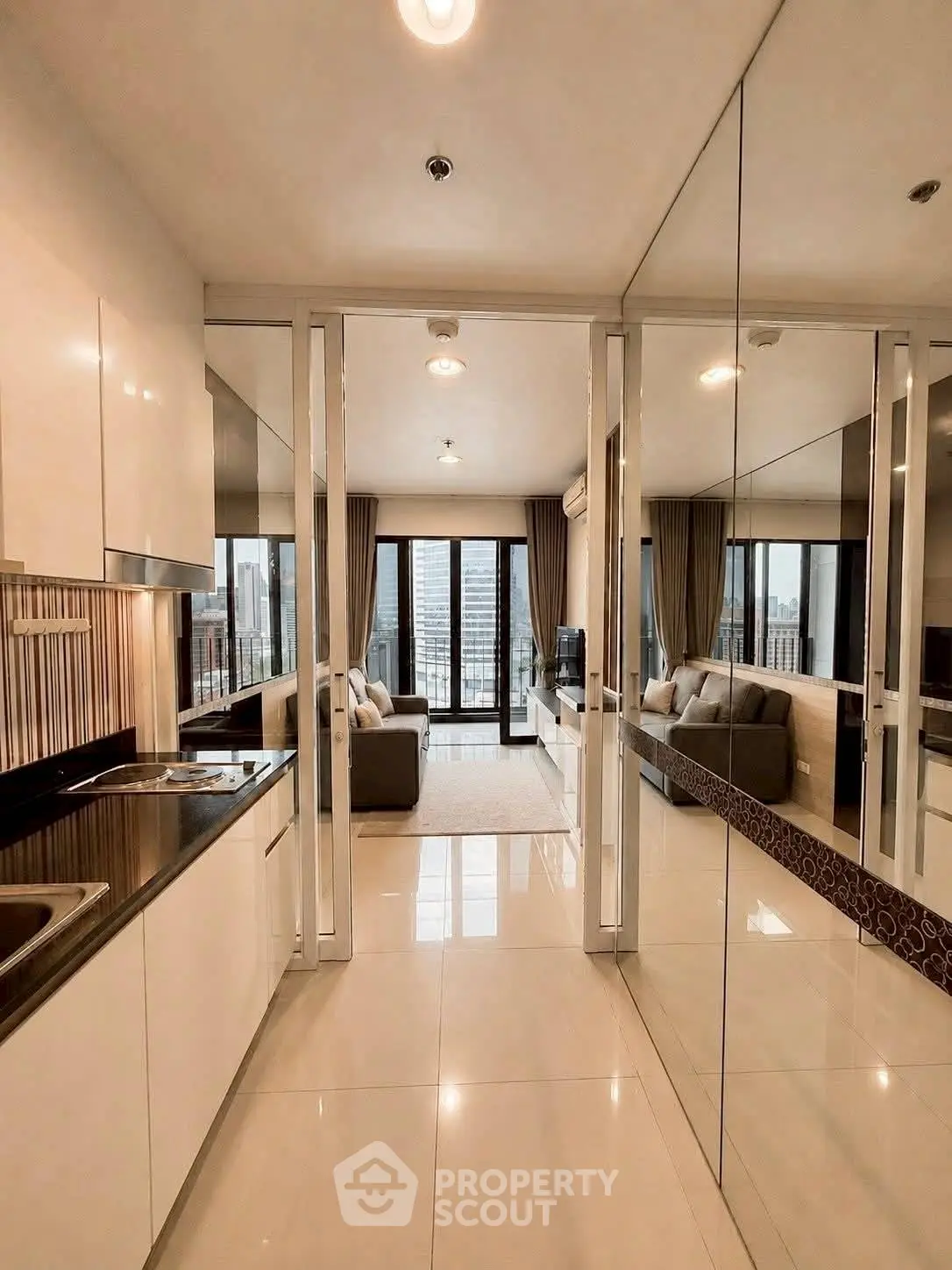 Modern open-layout apartment with sleek kitchen and spacious living area, featuring floor-to-ceiling windows and city views.