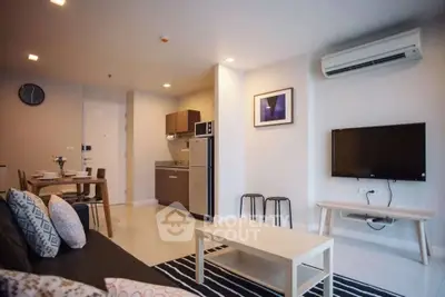 Modern living room with open kitchen, stylish decor, and air conditioning.