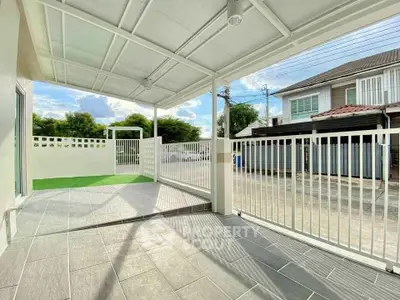Spacious covered patio with modern railing and street view, perfect for outdoor relaxation.