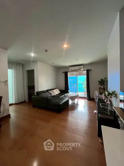 Spacious living room with modern decor and balcony access in a stylish apartment.