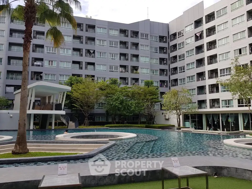Modern apartment complex with pool and lush greenery, offering a serene living environment.