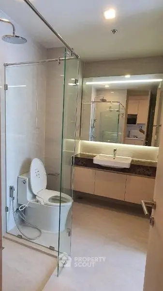 Modern bathroom with glass shower and sleek vanity in upscale apartment