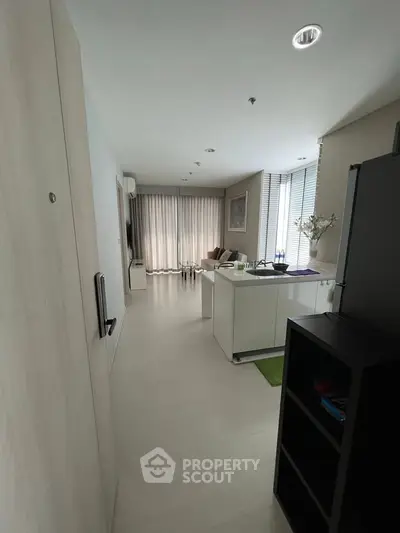 Modern living room with open layout and natural light, featuring sleek furniture and stylish decor.