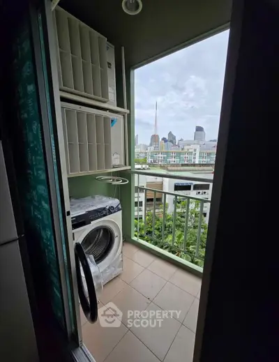 Compact balcony with city view and washing machine, ideal for urban living.